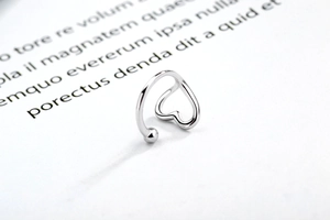 Macro shot of silver 925 cuff earring with minimalist hollow heart and smooth bead detail