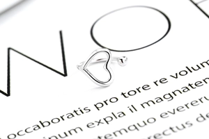 Detail shot of a minimalist 925 silver hollow heart ear cuff with a small round metal bead