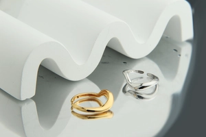 Detailed macro of S925 sterling silver stamp on minimalist wavy dual-tone rings