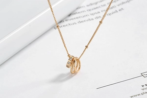 Detail view of gold triple-interlocking circle pendant necklace with sparkling zircons