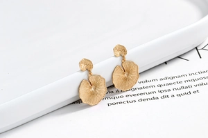 Macro shot of gold leaf earrings with textured s925 silver and brushed metal finish