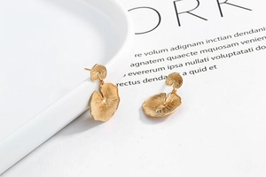Detailed view of gold plated sterling silver earrings with textured leaf design