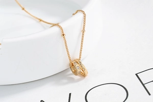Close-up of gold interlocking double rings necklace with crystals on satellite chain