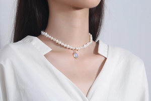 Close-up of Baroque pearl necklace featuring an iridescent moonstone oval pendant