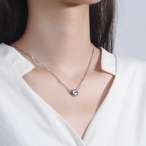 Minimalist S925 sterling silver bean pendant necklace worn by a model in a white shirt