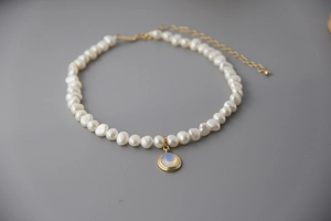 Detailed shot of 925 silver pearl necklace featuring a moonstone pendant and gold clasp