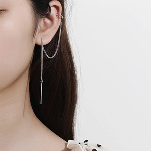 Detail of S925 silver ear cuff with long tassel chain and minimalist metallic cylinder drop
