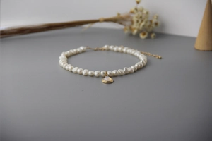 Detailed macro view of baroque pearl necklace with moonstone pendant and gold clasp