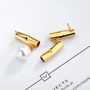 Detailed view of bamboo-shaped gold earrings with lustrous round white pearls