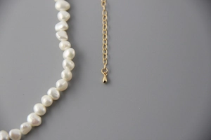 Detailed close-up of natural baroque pearls with a gold-plated adjustable chain extender