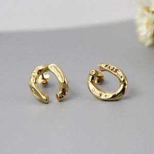 Detail of gold crescent studs with hammered texture and minimalist S925 silver finish