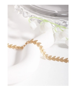 Detailed close-up of golden leaf-shaped links with realistic textures on a choker necklace