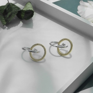 Detail of interlocking S925 sterling silver hoop earrings with pavé set zirconia stones