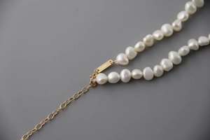 Macro shot of S925 sterling silver stamp on natural baroque pearl necklace closure
