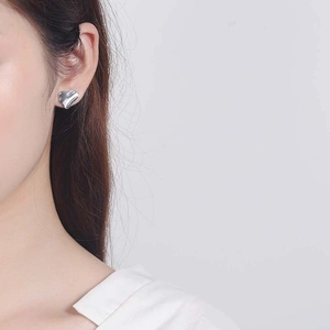 S925 sterling silver heart-shaped stud earrings with artistic wavy texture on model