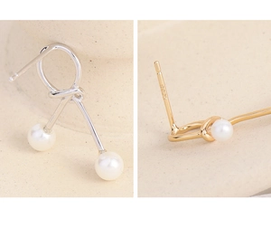 Macro view of S925 sterling silver knot earrings featuring small white pearls