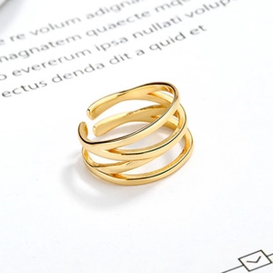 Close-up of triple-layered criss-cross gold ring with polished rhombic texture details