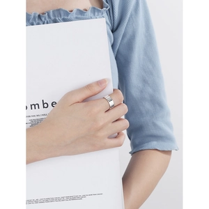 Modern S925 sterling silver wide ring featuring vertical grooved texture on model hand
