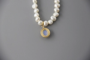 Macro shot of 925 sterling silver baroque pearl necklace with blue moonstone pendant