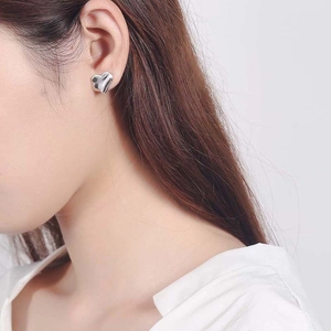 Elegant S925 sterling silver heart-shaped stud earrings worn on a female model
