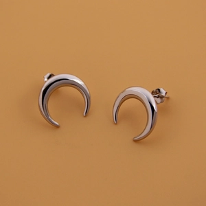 Macro view of minimalist S925 sterling silver crescent moon earrings with polished finish