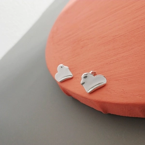 Macro shot of S925 sterling silver heart earrings with unique layered fold textures