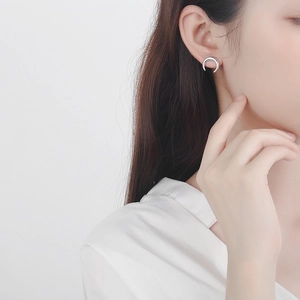 Detail view of a minimalist S925 sterling silver crescent moon earring worn by a model