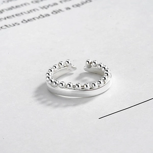 Macro shot of silver S925 double-layer open ring with polished finish and beads