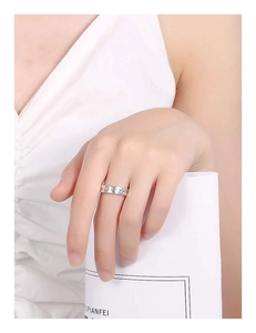 Detailed view of silver band ring featuring engraved star, moon, and smiley face motifs