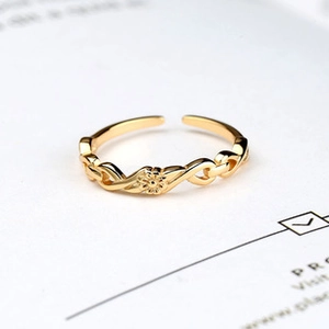 Macro detail of golden sunflower infinity ring with polished texture on white background