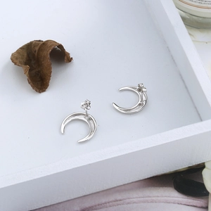 Detail shot of minimalist S925 silver crescent moon earrings in a lifestyle setting