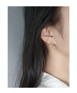 Detail of S925 silver gold knotted stud earrings with parallel bars and twin pearls