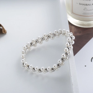 Double-row beaded bracelet with white pearls and silver metal beads on a white tray