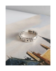 Close-up of S925 sterling silver ring featuring engraved star and smiley face patterns