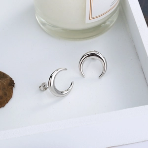 Close-up of S925 sterling silver crescent moon stud earrings with a polished mirror finish