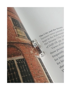 Macro detail of retro S925 sterling silver ring with star and smiley face on book page