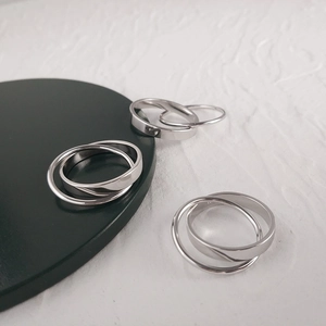 Macro shot of silver triple interlocked rings on a black display tray with polished finish