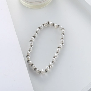 Detail of silver beads and white imitation pearls woven in a multi-layer beaded bracelet