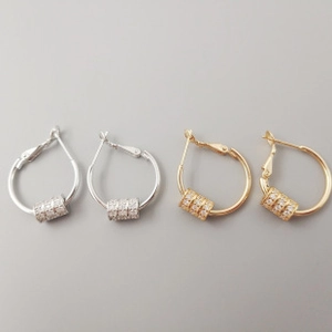 Detailed close-up of S925 silver and gold dolphin hoop earrings with pave cubic zirconia