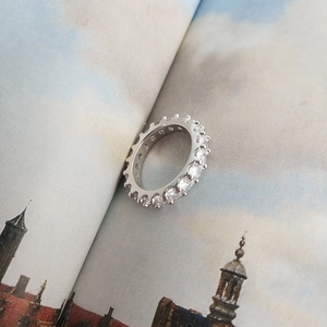 Detailed view of S925 sterling silver eternity ring with zircon stones on a book
