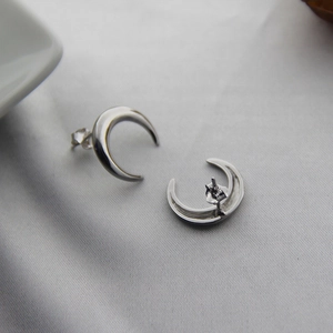 Detail view of crescent moon silver earrings featuring polished finish and butterfly backs