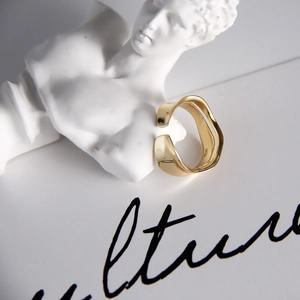 Macro shot of minimalist gold S925 sterling silver wavy ring showing engraved stamp