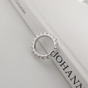 Macro shot of silver eternity ring with zircon stones set on a gear-shaped band