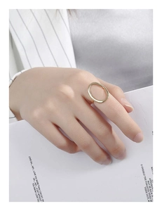 Detailansicht eines hohl geformten ovalen Rings in Goldoptik am Finger