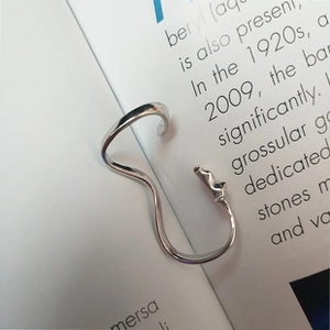 Close-up of a silver irregular wavy open bangle with a liquid metal flowing design