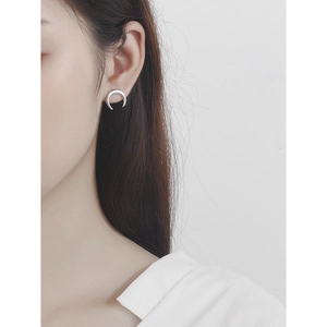 Minimalist S925 sterling silver crescent moon stud earrings worn on a female model