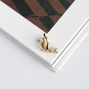 Detailed close-up of a gold dolphin ear cuff featuring intricate micro-pave crystals