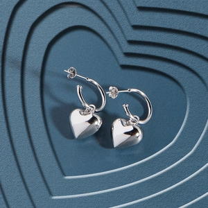 Minimalistische S925 Silber Herz Ohrringe mit polierter Oberfläche auf blauem Hintergrund