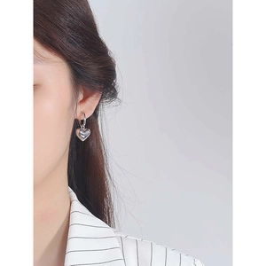 Minimalistische Herz-Ohrringe aus S925 Sterlingsilber, getragen von einem Modell