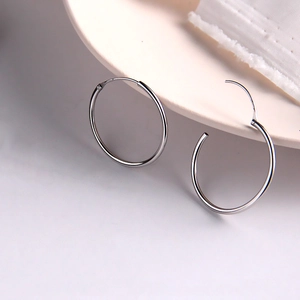 Créoles minimalistes en argent sterling S925 avec finition polie sur assiette céramique